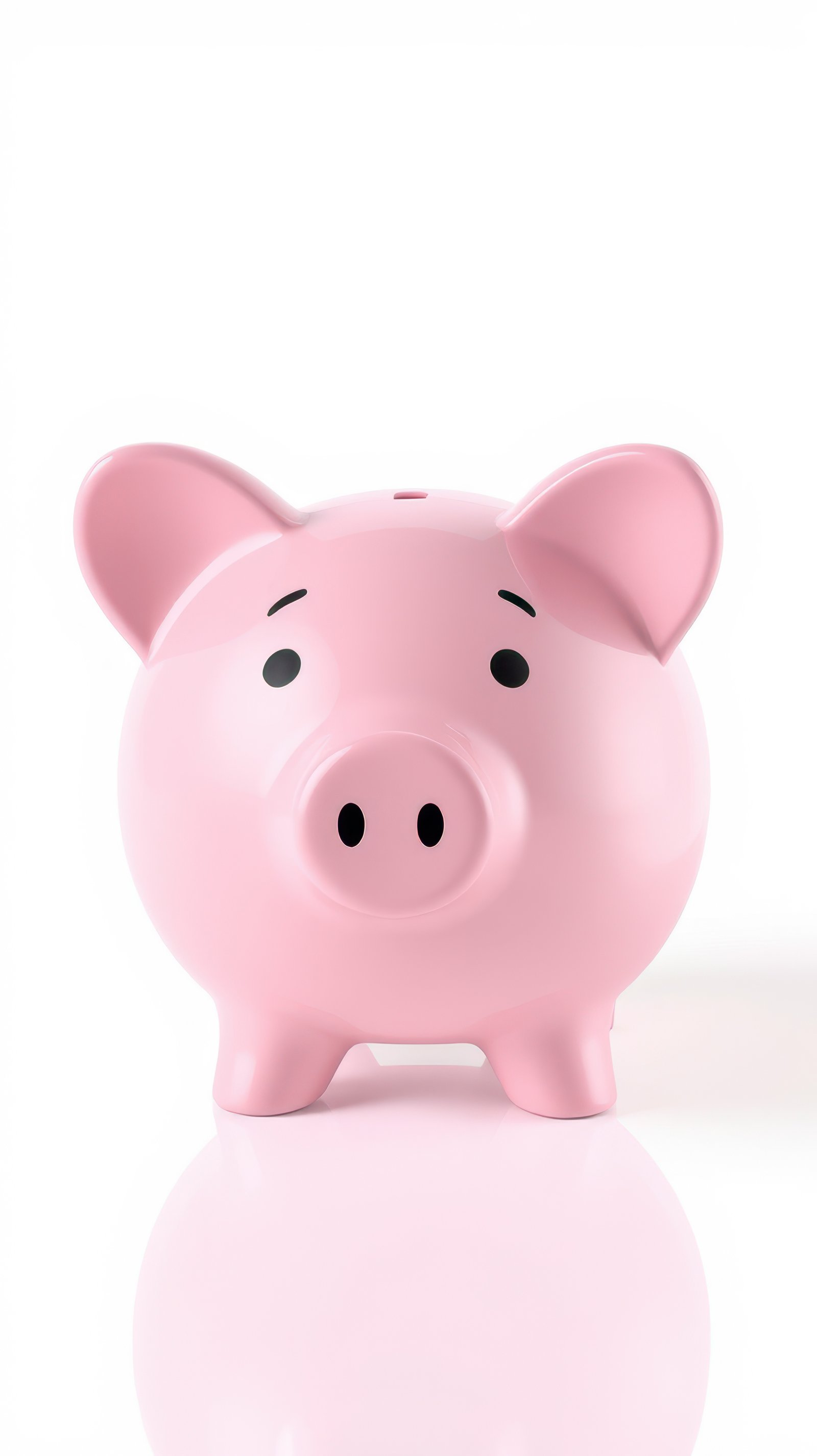 Cute pink piggy bank standing on a reflective surface against a plain white background
